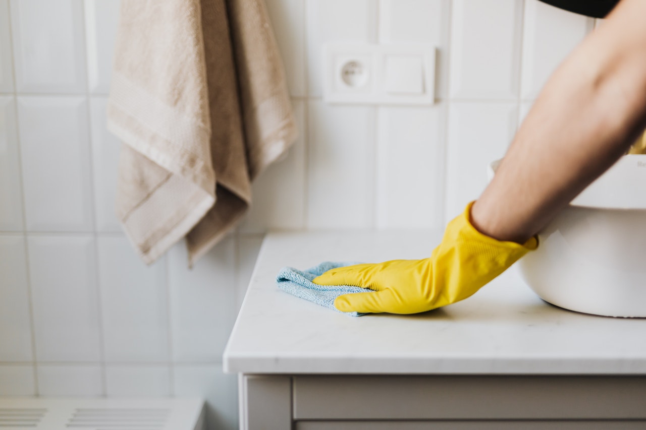 crop-housewife-cleaning-surface-near-sink-4239037